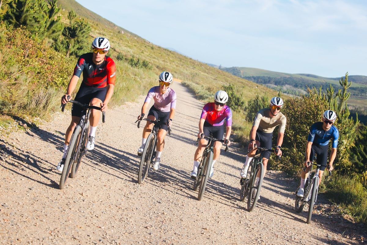 Five riders in RH77 kit riding a gravel road